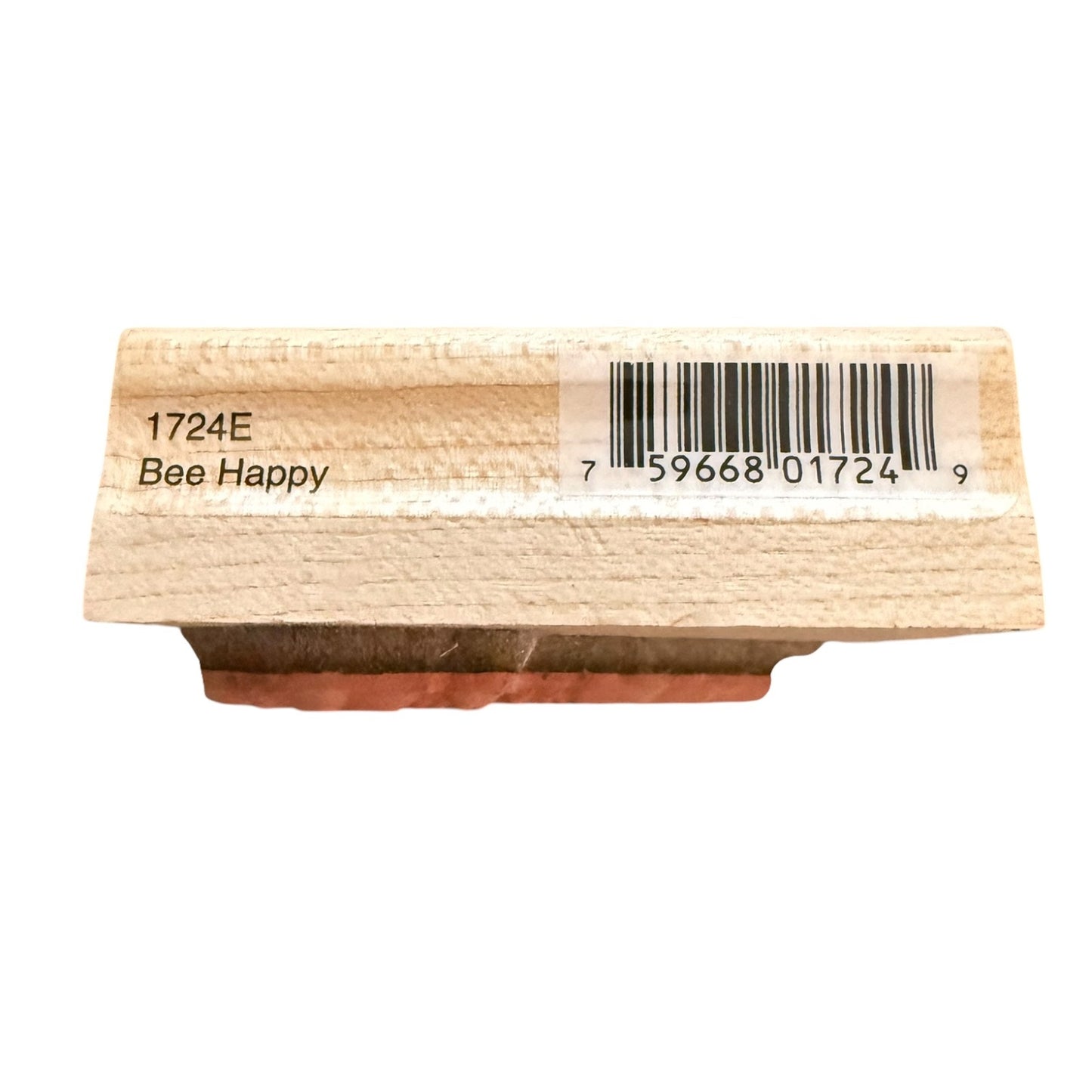A wooden stamp block with a rubber stamp base, featuring the text '1724E Bee Happy' and a barcode on a white background.