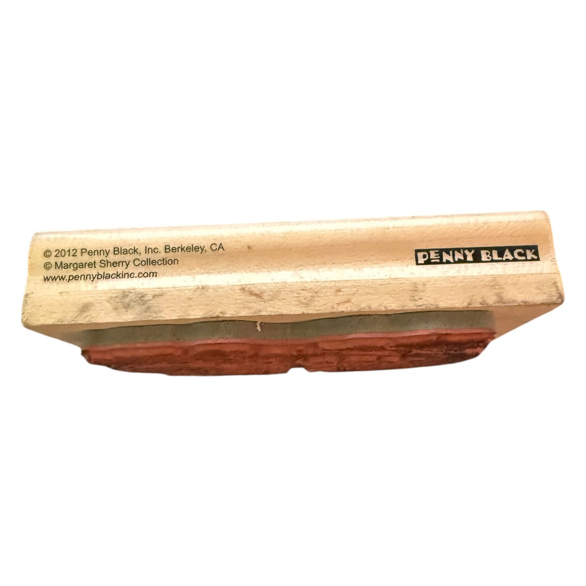 Side of wood block of stamp with Penny Black printed on the side on a white background. 