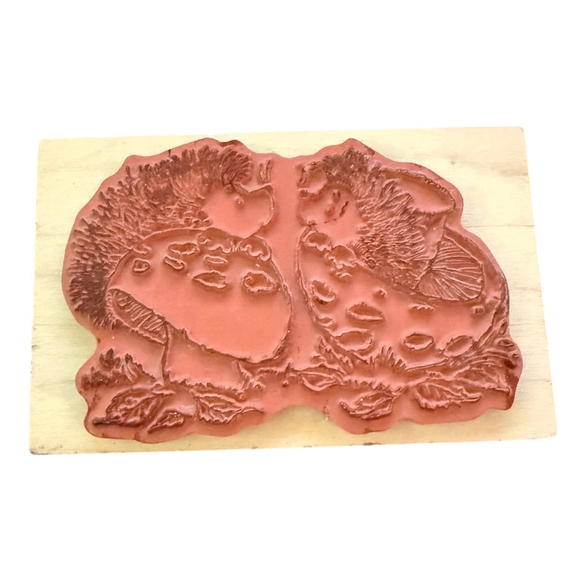 Pink rubber stamp on a wood block with a white background. 