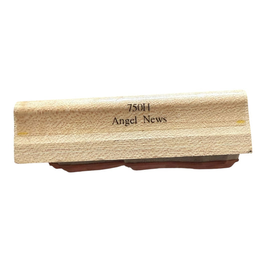 Wooden stamp with '750H Angel News' text on a white background
