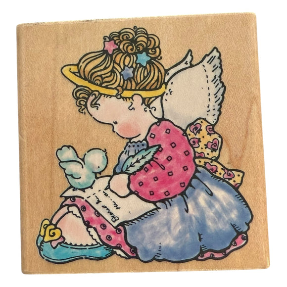 Wooden block with a colorful illustration of an angel holding a bird on a beige background