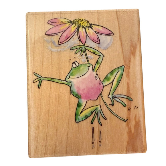 Wooden block with a colorful illustration of a frog holding a flower on a white background