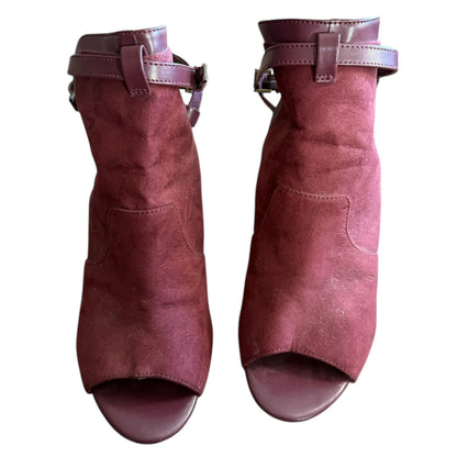 Front of a Pair of maroon open-toe shoes with buckles on a white background