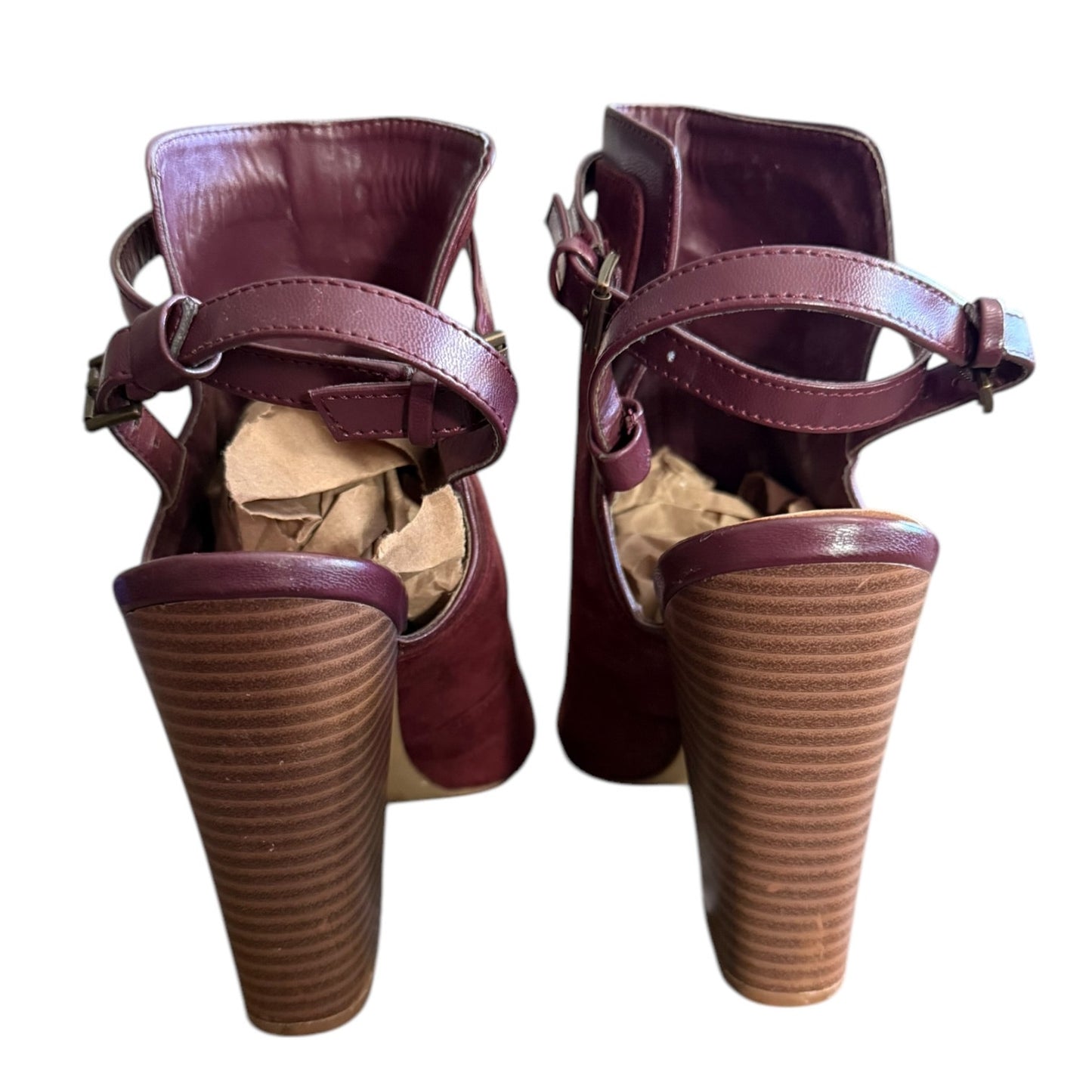 Back of a Pair of maroon high-heeled shoes with pointed toes on a white background