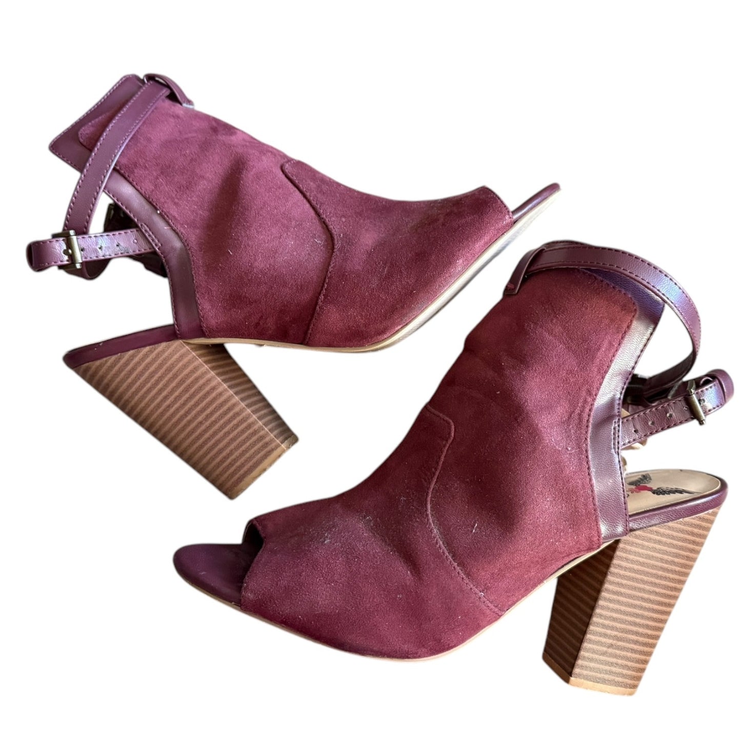 Side of a Pair of maroon high-heeled shoes on a white background
