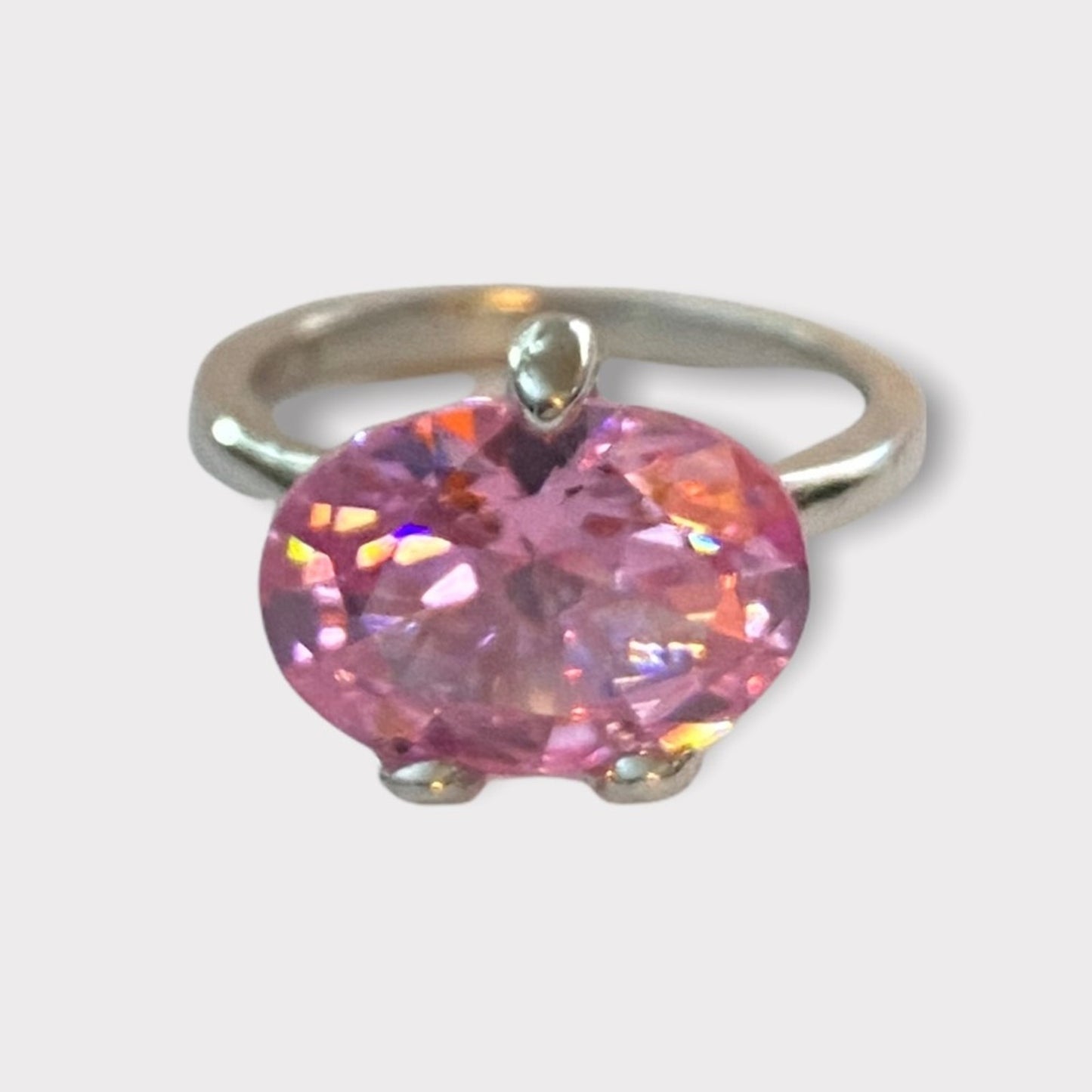 Ring with a pink gemstone on a light gray background