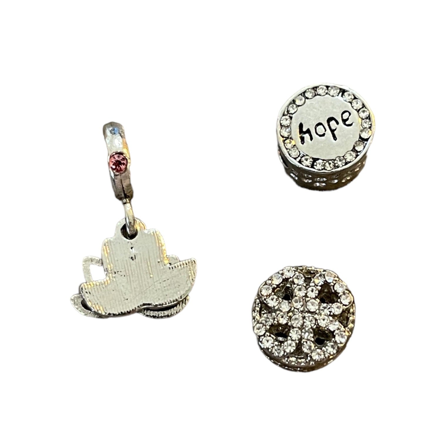 Three silver charms on a white background
