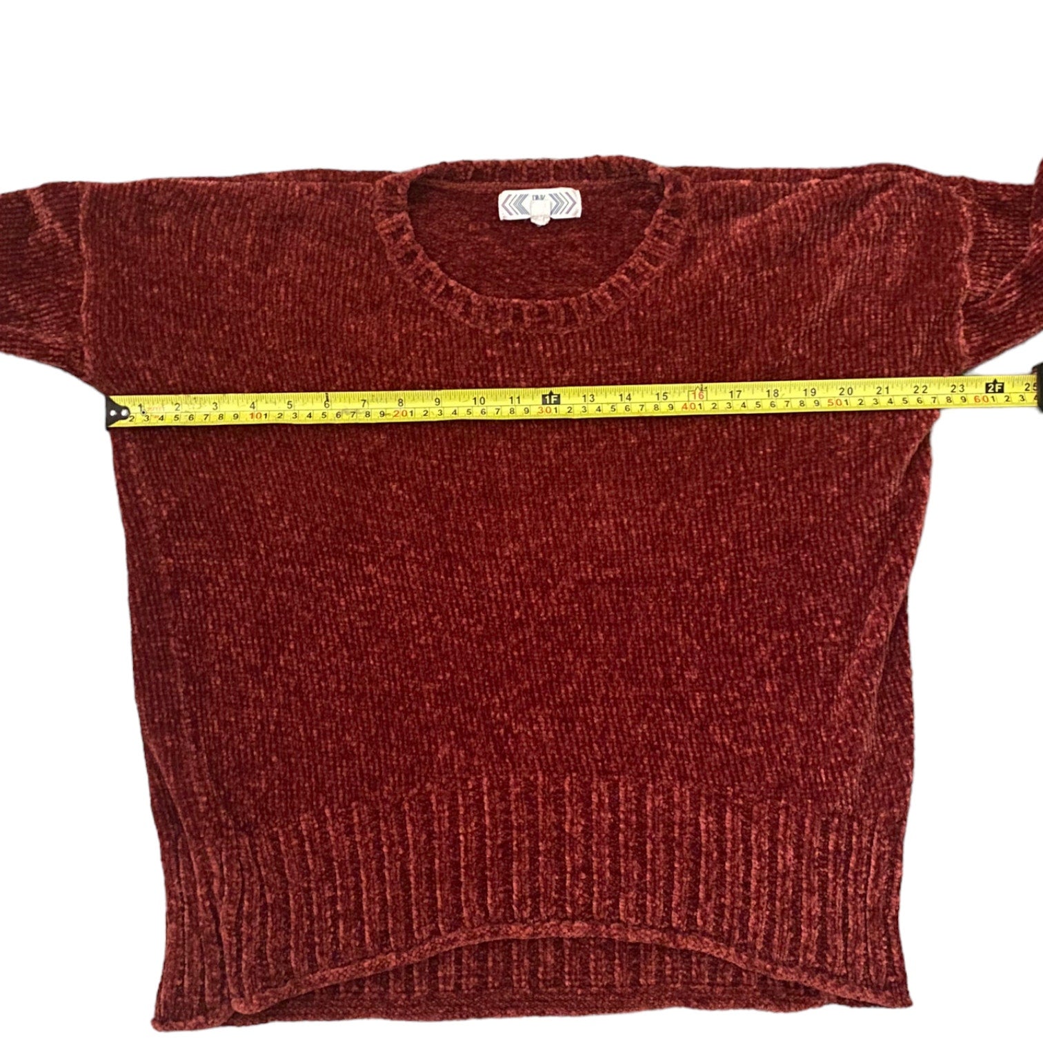 Red/pink sweater with a measuring tape draped over it on a white background