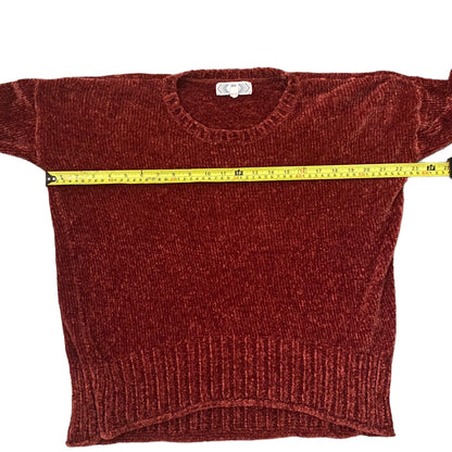 Red/pink sweater with a measuring tape draped over it on a white background