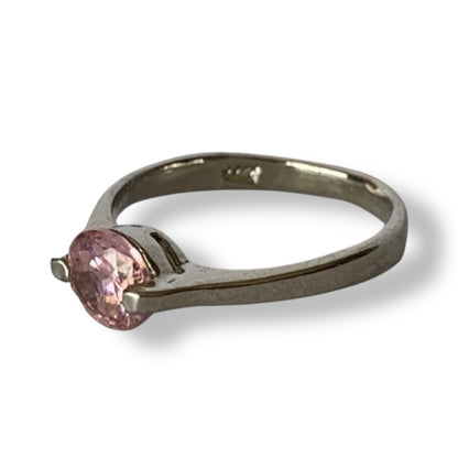 Silver ring with a pink gemstone on a white background