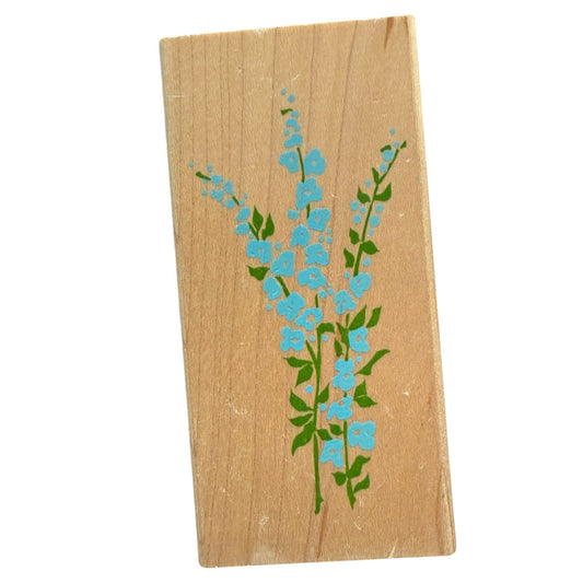 Wooden stamp block with blue floral design on a white background