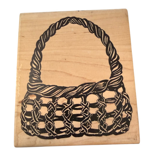 Wood block rubber stamp with a basket on it on a white background. 