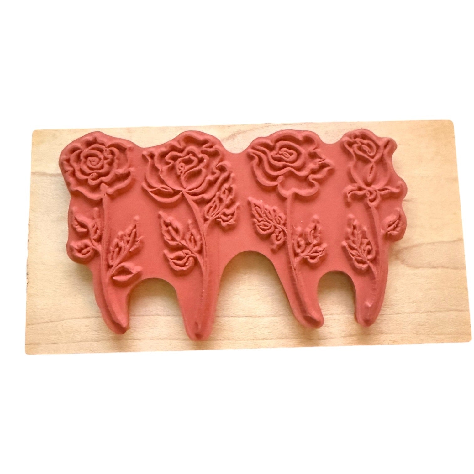 Red floral design rubber stamp on a wooden block