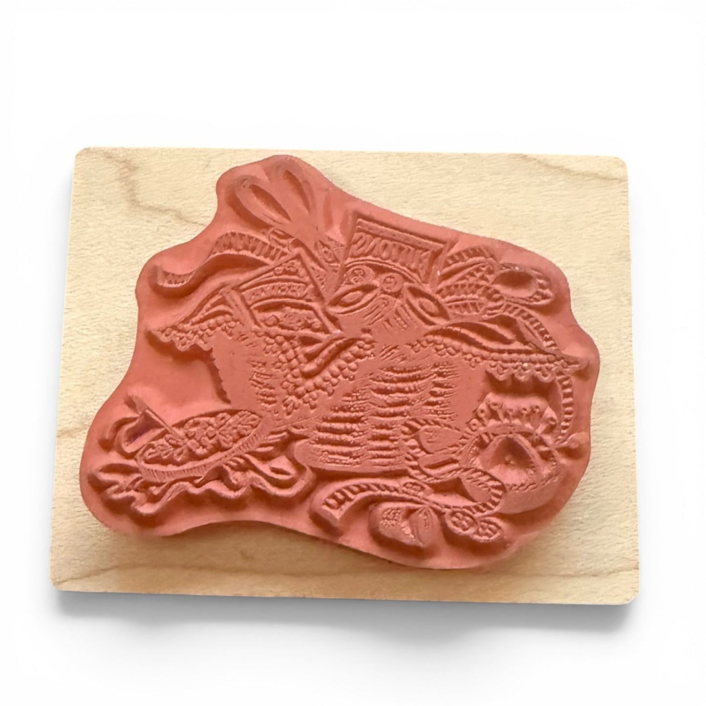 Decorative rubber stamp with intricate design on a wooden block