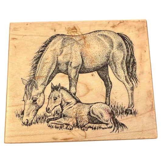 Wooden stamp with a design of a horse and foal on a white background