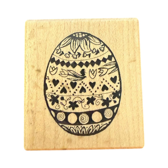 Wooden stamp with a black decorative Easter egg design on a white background