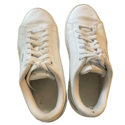 Top of a Pair of white sneakers with visible wear on a white background
