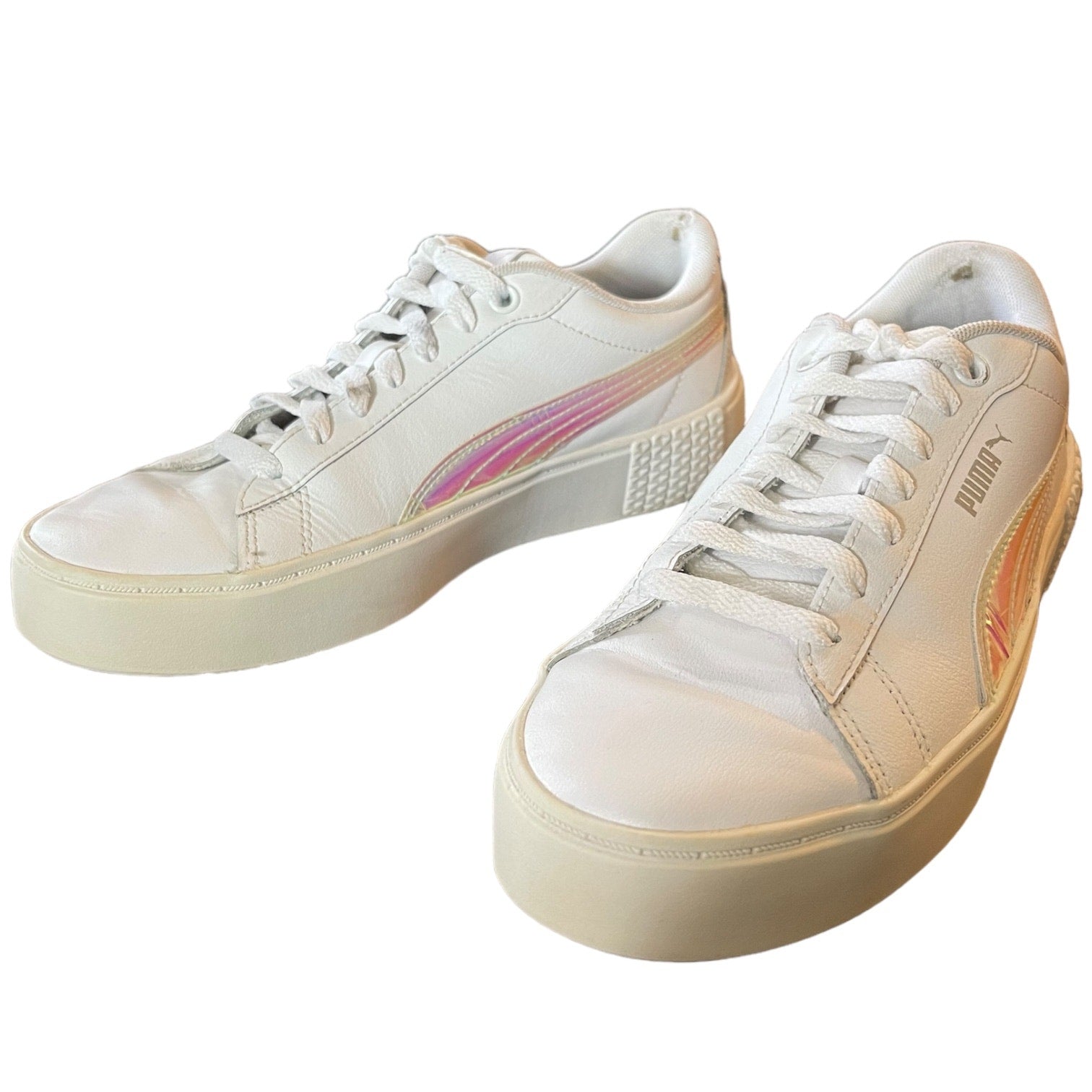 Pair of white sneakers with pink accents on a white background