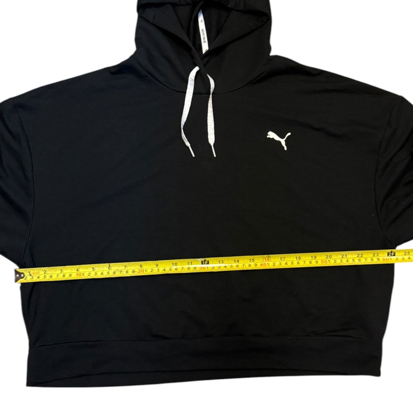 Black hoodie with a measuring tape around it on a white background