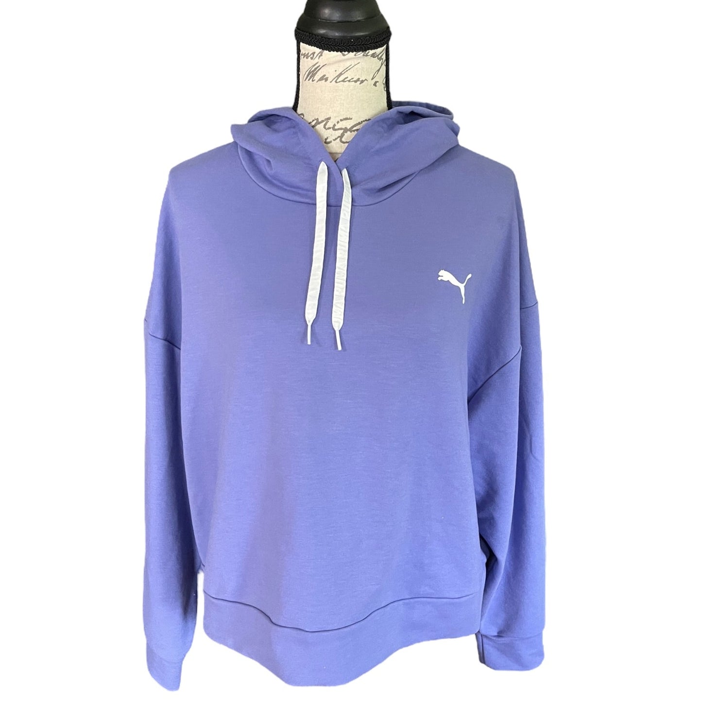 A lavender-purple Puma pullover hoodie displayed on a mannequin torso against a white background. The hoodie features white drawstrings and a small white Puma logo on the left chest.