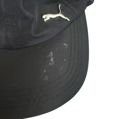 Black cap with a logo on a white background with leftover sticker residue