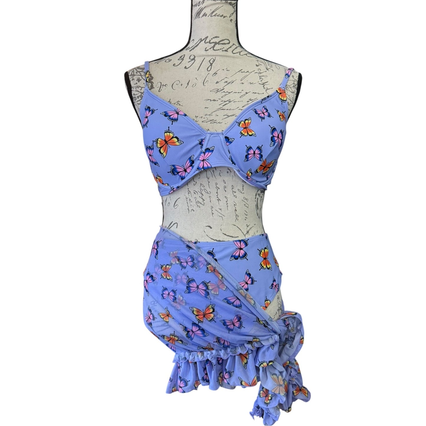 Purple butterfly-patterned bikini set on a mannequin against a white background