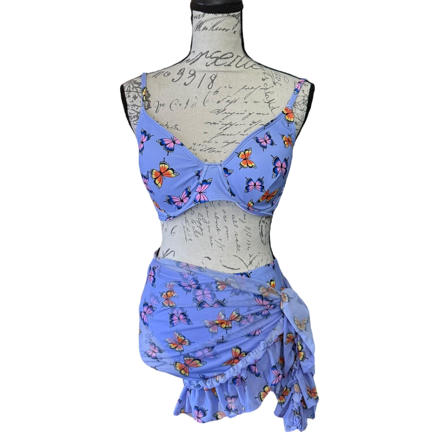 Front of purple butterfly-patterned three-piece outfit on a mannequin against a white background