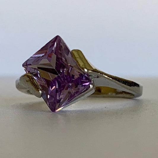 Silver ring with a large purple gemstone on a light background