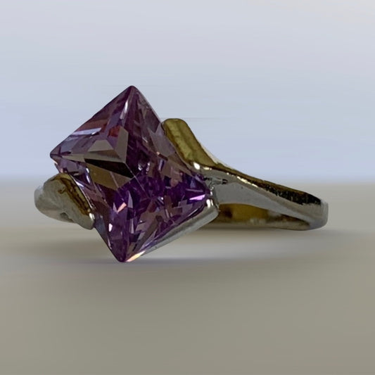 Silver ring with a large purple gemstone on a light background