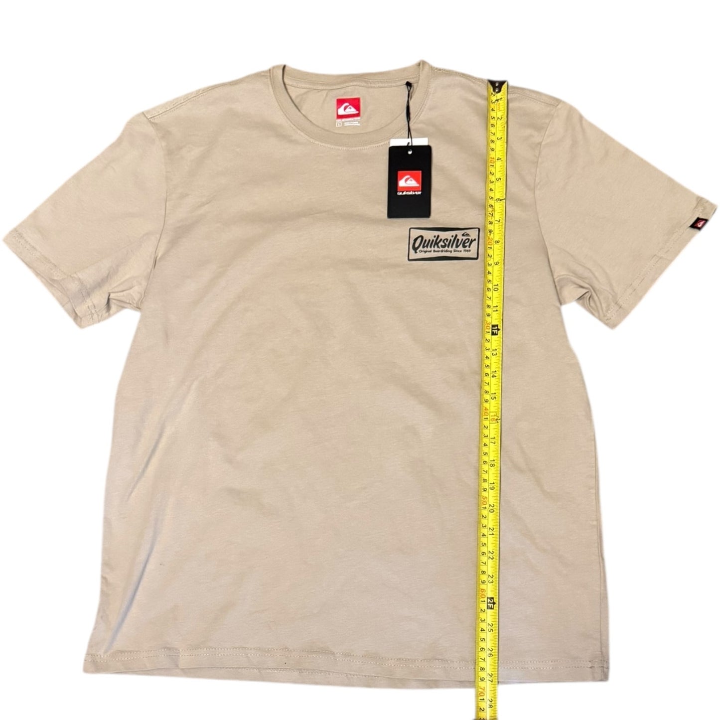 Beige t-shirt with Quiksilver logo and a measuring tape on a white background