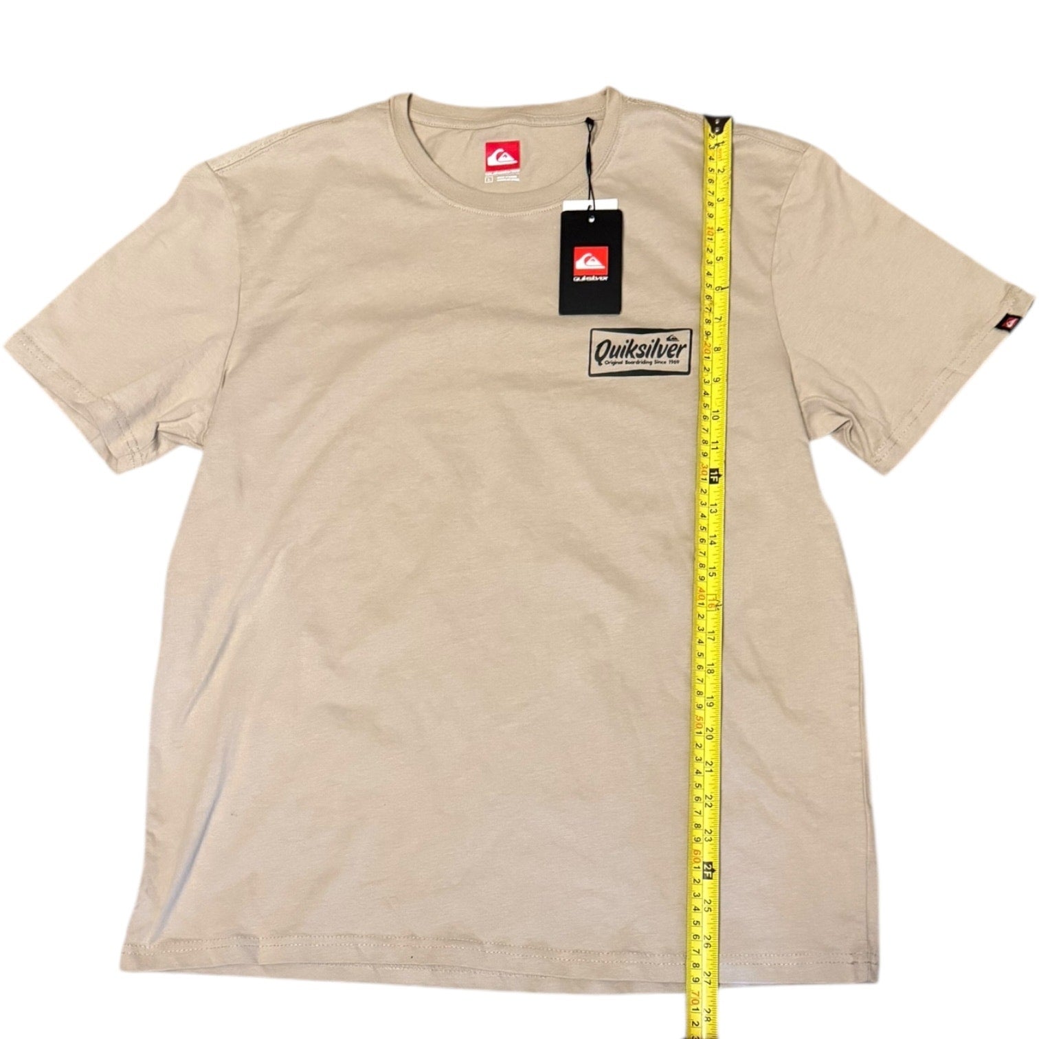 Beige t-shirt with Quiksilver logo and a measuring tape on a white background