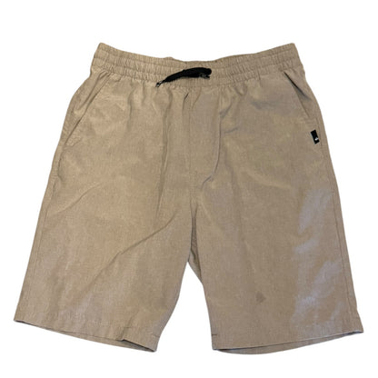 A pair of boy's casual shorts in a beige color, featuring an elastic waistband with a black drawstring and a small black brand tag on the left hip, laid flat against a white background.