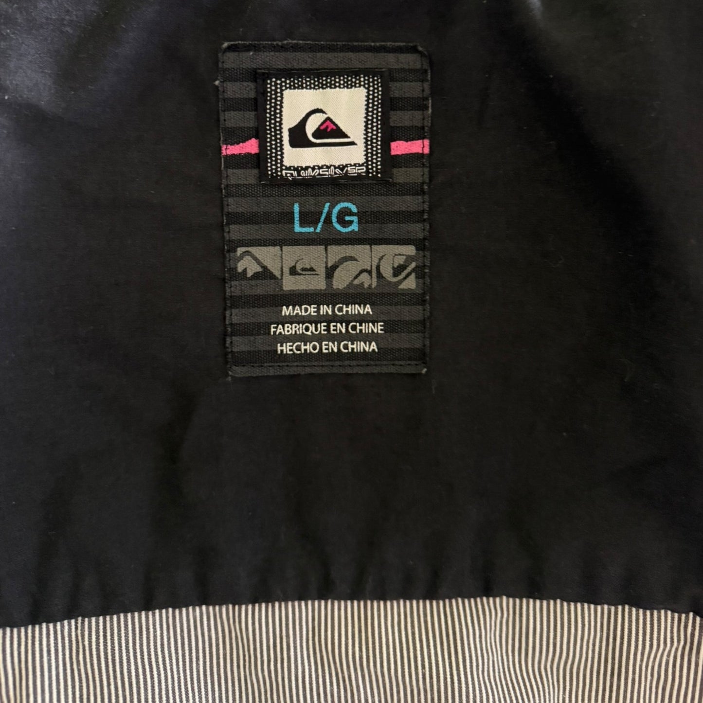 Clothing label on a black jacket with text and branding.