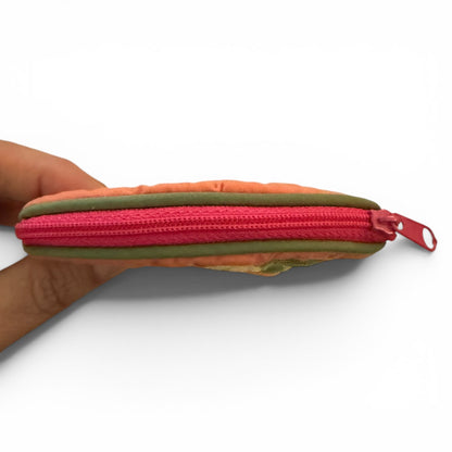 Multicolor pouch with a pink zipper held by a hand on a white background