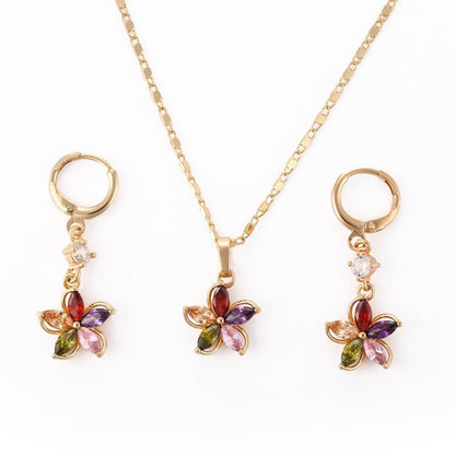 Gold flower necklace and earrings with multicolored faux gemstones on a white background