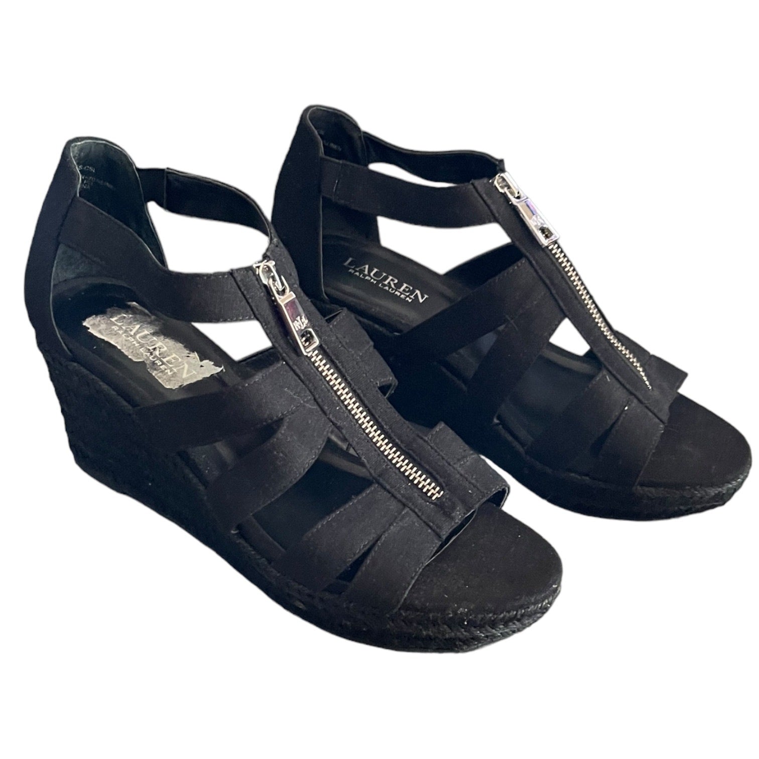 Black wedge sandals with a strap and zipper on a white background