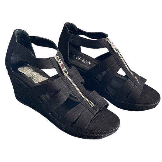 Black wedge sandals with a strap and zipper on a white background