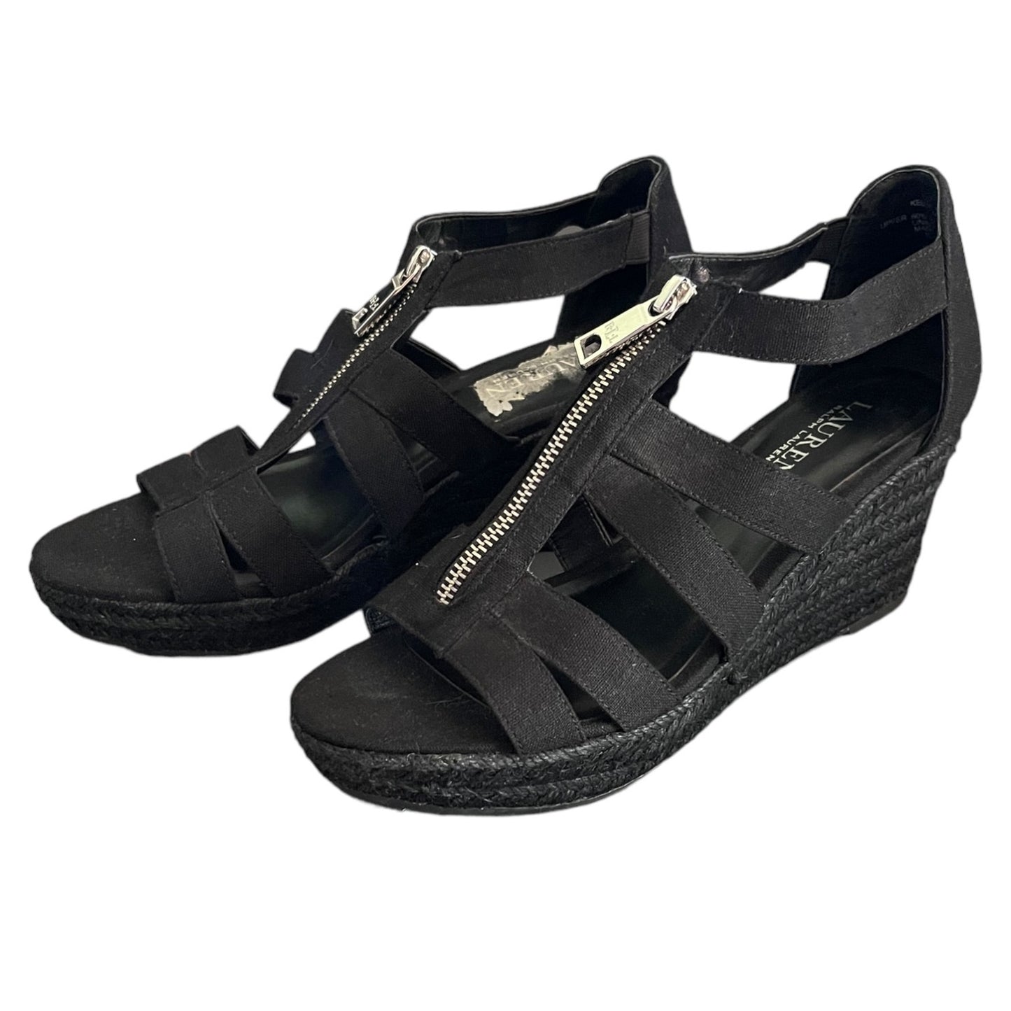 Black wedge sandals with cut-out design on a white background