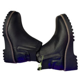 Black faux leather boots with thick soles  on their side on a white background