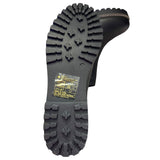 Close-up of a black boot sole with tread pattern on a white background