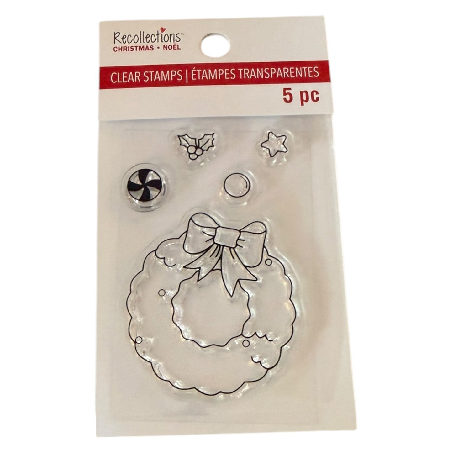 Recollections Christmas Clear Stamps in a 5-piece set, featuring a clear wreath stamp with a bow, holly, star, and snowflake designs, packaged in a clear plastic sleeve with a white and red header card.