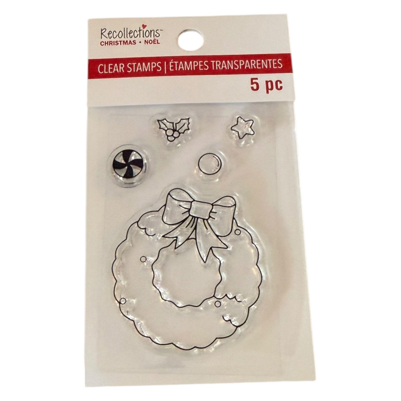 Recollections Christmas Clear Stamps in a 5-piece set, featuring a clear wreath stamp with a bow, holly, star, and snowflake designs, packaged in a clear plastic sleeve with a white and red header card.