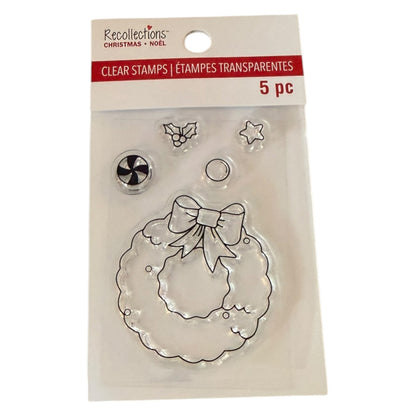 Recollections Christmas Clear Stamps in a 5-piece set, featuring a clear wreath stamp with a bow, holly, star, and snowflake designs, packaged in a clear plastic sleeve with a white and red header card.