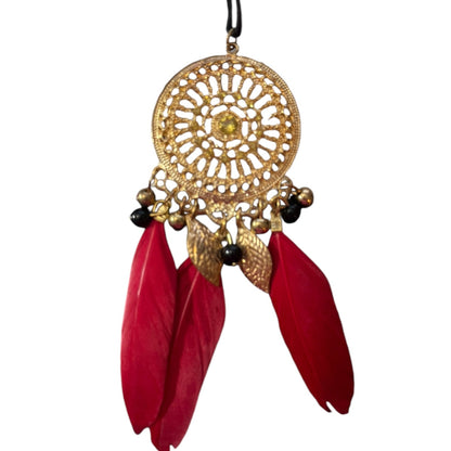 Decorative hanging pendant with gold circular design and red feathers on a white background