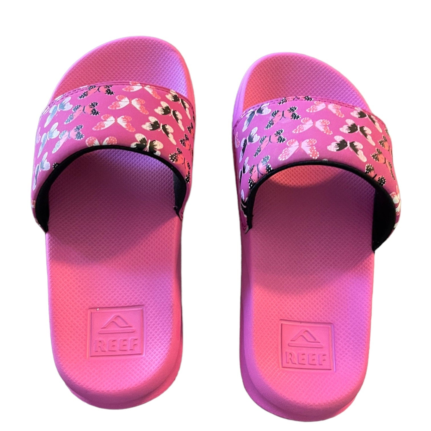 Top of Pink slides with floral strap and Reef logo on a white background