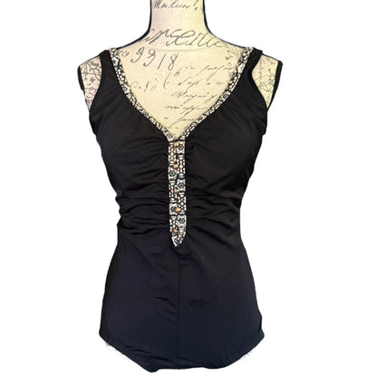 Black swimsuit front with decorative neckline on a mannequin against a white background
