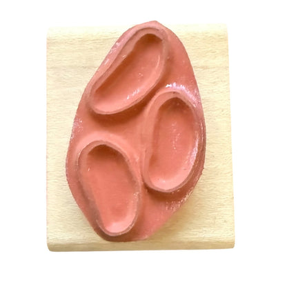A terracotta-colored rubber stamp of jelly beans, shown on a light-colored wooden block against a white background.