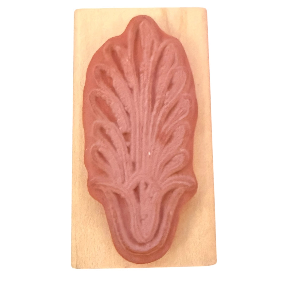 A botanical rubber stamp with a terracotta-colored leaf design mounted on a light-colored wooden block, shown against a plain white background.