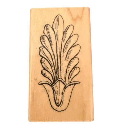 A rectangular wooden rubber stamp featuring a black ink botanical design of a stylized leaf , shown on a plain white background.