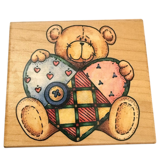 Wooden block with a teddy bear holding a heart design on a white background